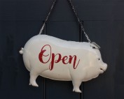 photo of shop open sign is shape of a pig